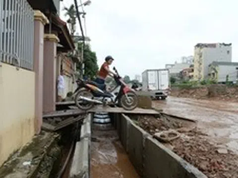 Đường cao hơn nền nhà gần 1 m, người dân chật vật 'bắc cầu' để đi lại